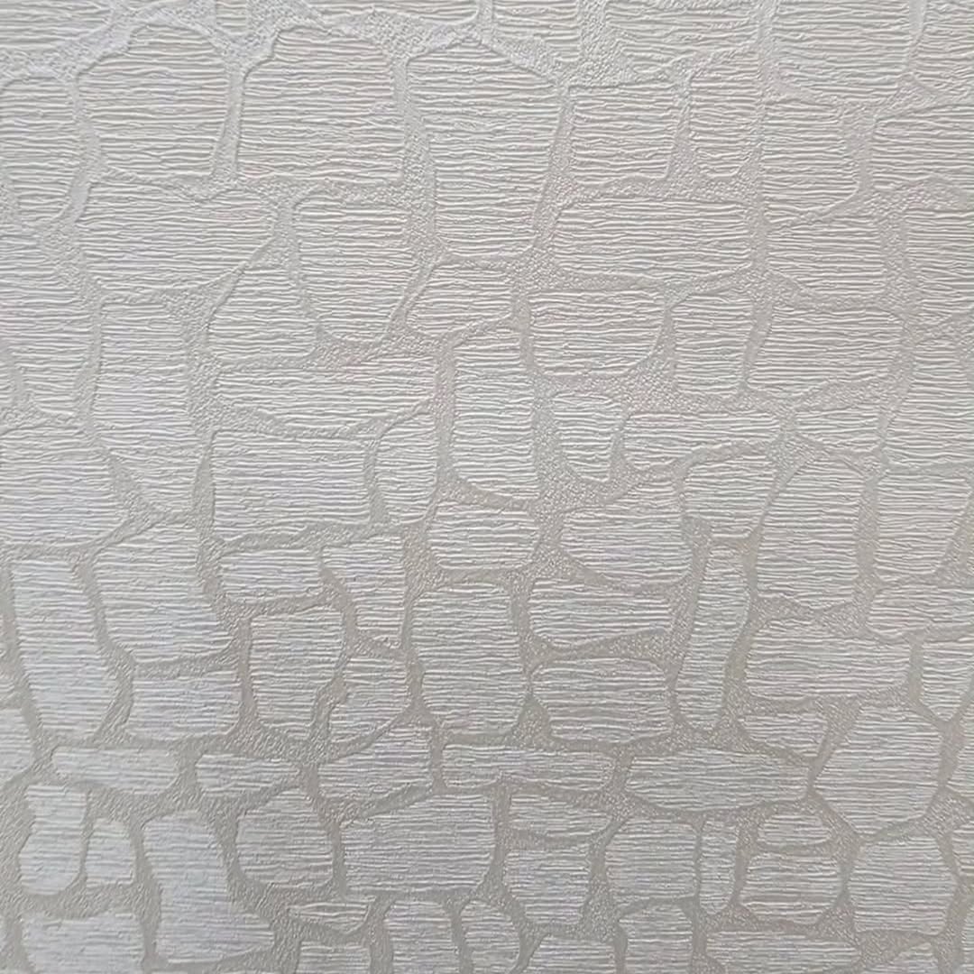 A macro shot of off-white textured wallpaper. The pattern consists of irregular, raised shapes resembling flat stones or pebbles. Each shape has a fin